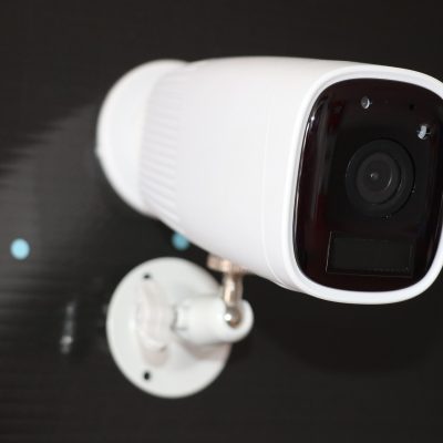 white security camera on black wall